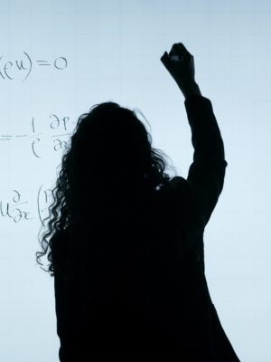 Silohette of a women writing on a white board